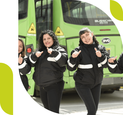 Cuatro mujeres con chaquetas negras con dos buses verde de tras.