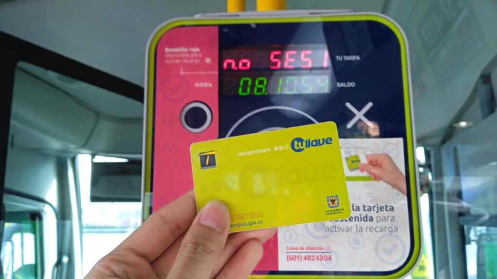 Tarjeta de TuLlave verde acercandose al validador de pasajes.