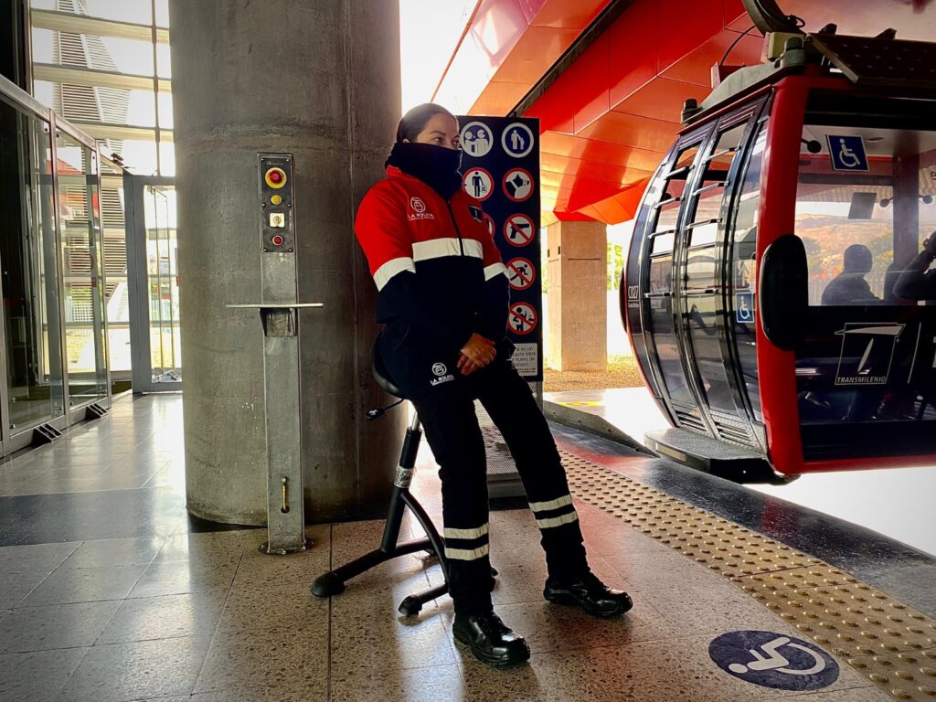 Personal de embarque en TransMiCable sentado en una silla al lado de una cabina.