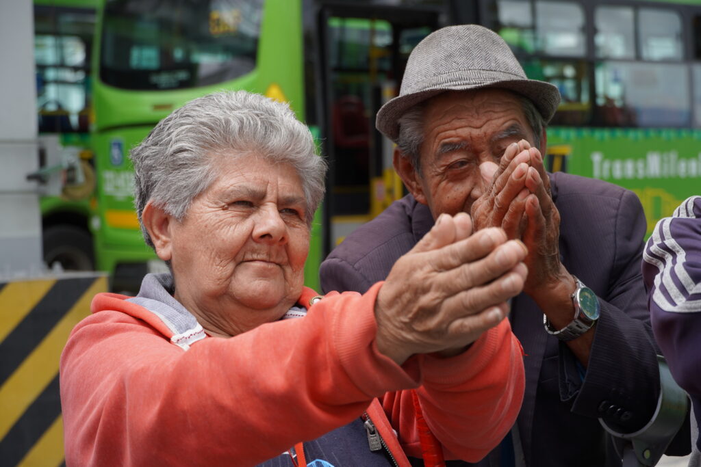 Pareja de personas mayores haciendo ejercicio de visibilidad ocn las manos.